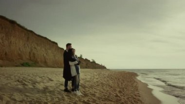 Tatilde sahilde kucaklaşan bir çift. Mutlu melez aşıklar okyanus kıyısında sarılırlar