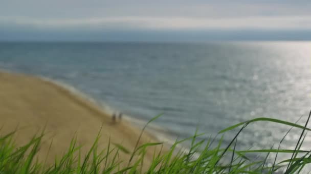 Красивий морський пляжний пейзаж. Двоє людей насолоджуються відпочинком на узбережжі океану — стокове відео
