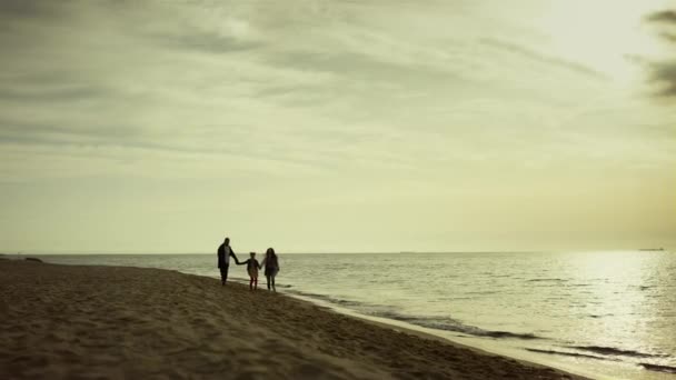 Aile yürüyüşü sabah plajı. Gençler boş gündoğumu sahili üzerinde koşuyor. — Stok video