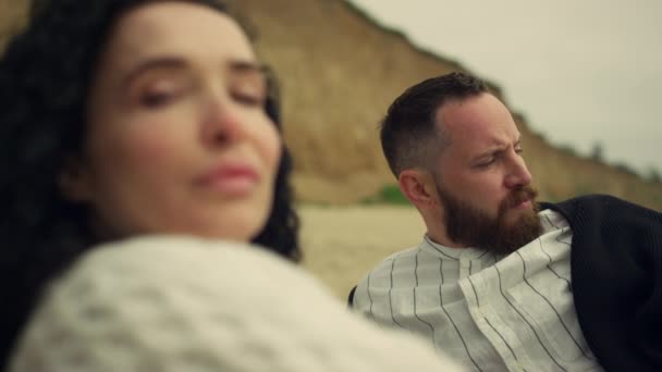 Multiethnisches Paar blickt Kamera am Strand des Meeres. Zwei Liebende genießen es, draußen zu liegen. — Stockvideo