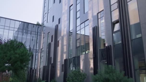 Moderne stedelijke kantoorarchitectuur gebouw. Glazen panelen reflecteren heldere lucht. — Stockvideo