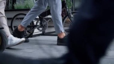 Yakın çekim yöneticileri şehir merkezinde bisiklet elektrikli scooterıyla yürüyor..