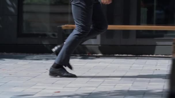 Selbstbewusster Mann, der im Anzug durch die Stadt läuft. Männliche Beine in schwarzen Schuhen Nahaufnahme. — Stockvideo