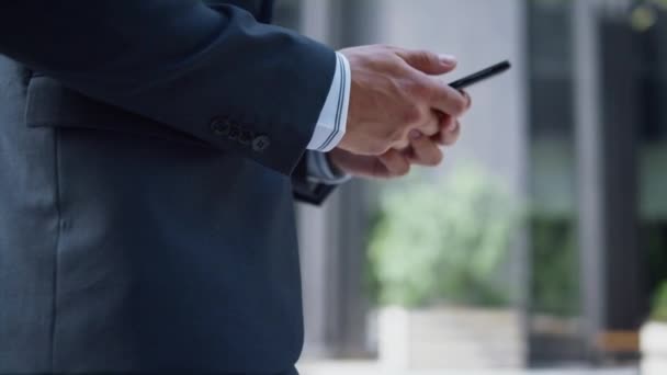 Επιχειρηματίας χέρια κρατώντας τηλέφωνο γραπτών μηνυμάτων closeup. Άνθρωπος που χρησιμοποιεί το περπάτημα smartphone. — Αρχείο Βίντεο