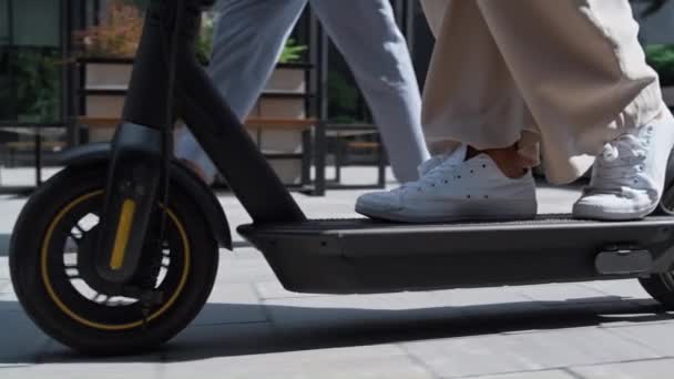 Closeup female legs riding kickscooter in white sneakers. Urban traveler concept — Stock Video