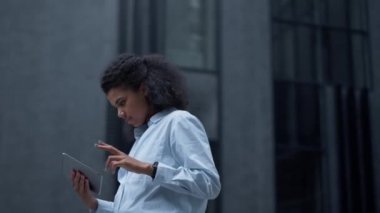 Modern ofis binasında duran tablet bilgisayarda çalışan profesyonel analist..