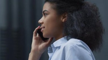 Dışarıda cep telefonuyla konuşan mutlu bir kadın. İçerik yöneticisi iş görüşmesinde