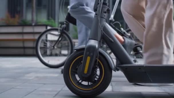 Managers benen lopen in de binnenstad straat. Voorste fiets scooter wielen close-up. — Stockvideo