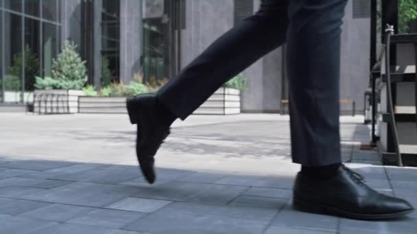 Уверенный менеджер, гуляющий в центре города на обеденном перерыве. Мужские ноги крупным планом. — стоковое видео