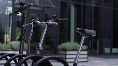 Otoparkta elektrikli scooterla duran yakın çekimli bisiklet. Gümüş gidon 