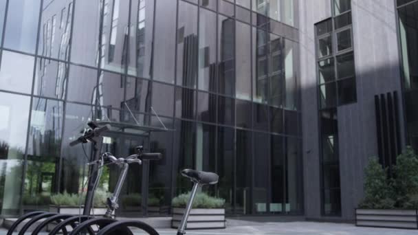 Sdílená vozidla stojící na parkovišti u moderní prosklené kancelářské budovy ráno — Stock video