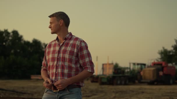 Agricultor olhando campo de trigo no pôr-do-sol de verão dourado. Conceito moderno de agronegócio — Vídeo de Stock