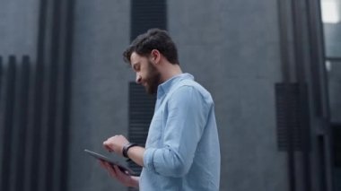 Modern ofis binasında tablet bilgisayar kullanan odaklanmış bir yönetici. Uygulama kullanıcısı.