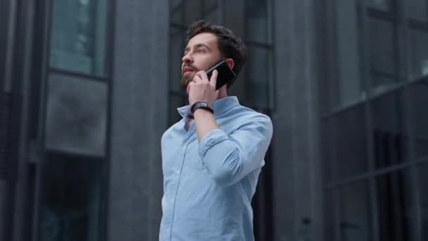 Ελκυστικός επιχειρηματίας που τηλεφωνεί στο σύγχρονο κτίριο και μιλάει με τον συνεργάτη του — Αρχείο Βίντεο