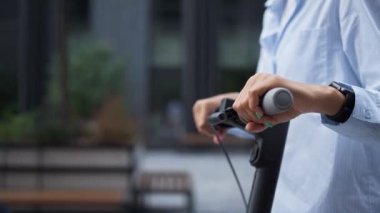 Şehir merkezinde elektrikli scooter kullanan kadın elleri. Şehir yolcusu.