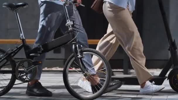 Рабочие ноги пешком в центре города с электрическим скутером велосипед в руках закрыть. — стоковое видео