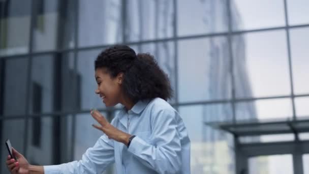 Mujer alegre haciendo videollamadas posando en una oficina moderna. Comunicación en línea — Vídeos de Stock