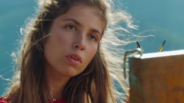 İlham verici ressam resim sehpasını yakından çiziyor. Yazın doğayı resmeden yaratıcı kız.