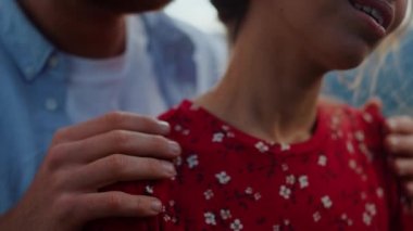 Şefkatli evlilik açık havada seksi hissettiriyor. Yakından erkek elleri kadının omuzlarını okşuyor.