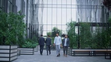 Ofis bahçesinde yürüyen iş adamları. Şehir merkezinde günlük rutin.