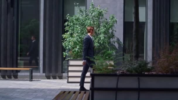 Focused finance manager walking to work occupation in contemporary gray exterior — Stock Video