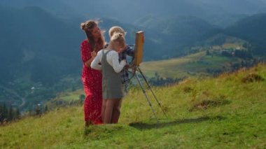 Mutlu aile açık havada dağ çiziyor. Ressam ve çocuklar resim yapıyor..