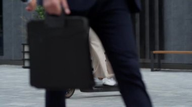 Kadın bacakları şehir merkezinde elektrikli scooter kullanıyor. Alternatif ulaşım.