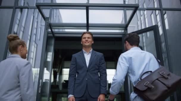 Heureux homme d'affaires debout à la porte du bureau rencontrant des travailleurs joyeux. Esprit d'équipe. — Video