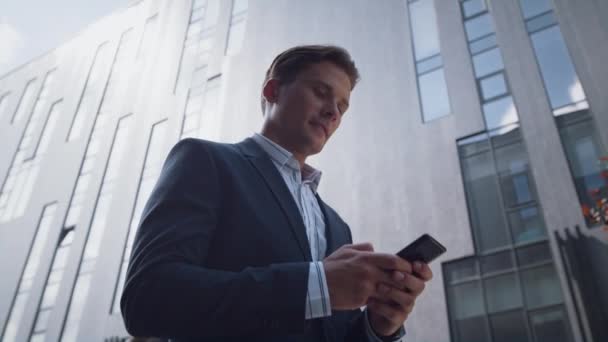 Succesvolle zakenman met behulp van smartphone gaan in de binnenstad wijk close-up. — Stockvideo