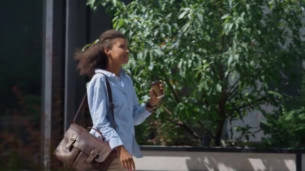 Gerente feliz va a trabajar sosteniendo la taza de café en el día soleado. Centro de distrito. — Vídeo de stock