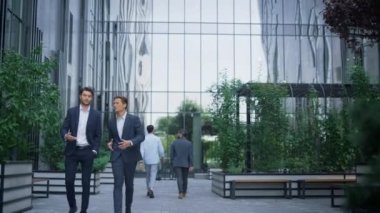 Modern ofis binasında yürüyen iki başarılı işadamı projeyi tartışıyor..