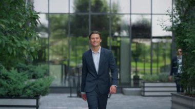 Kendine güvenen iş adamı takım elbise içinde şehir merkezinde yürüyor. Başarılı bir girişimci.