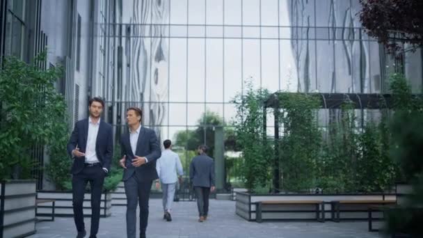 Två framgångsrika affärsmän promenader på moderna kontorsbyggnad diskuterar projekt. — Stockvideo