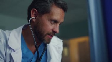 Koğuş portresinde steteskop kullanan sakallı doktor. Klinikte tıbbi muayene