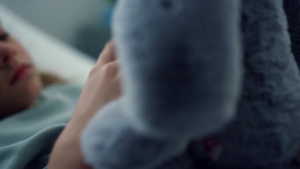 Portret zdenerwowanego dzieciaka bawiącego się pluszową zabawką. Pacjent pediatryczny — Wideo stockowe