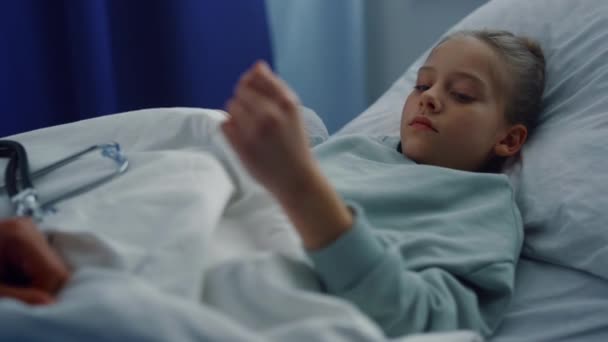 Zdenerwowana dziewczyna leżąca w szpitalnym łóżku poddana badaniu lekarskiemu na oddziale portretowym. — Wideo stockowe