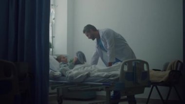 Arkadaş canlısı doktor koğuşta küçük bir hastayla konuşuyor. Modern ameliyathane içi.