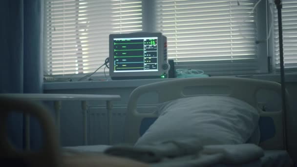 Cabezal de cama monitor de latidos cardíacos en unidad de cuidados intensivos. Equipos médicos en la habitación. — Vídeo de stock