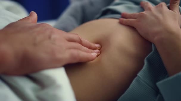 Doctor hands checking stomach of little sick girl in hospital ward closeup. — Stock Video