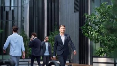 Memnuniyet duyulan iş adamı şehir merkezinde takım elbiseyle dolaşıyor..