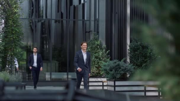 Uśmiechnięty biznesmen chodzący po biurowcu w garniturze. Koncepcja zwycięzcy. — Wideo stockowe