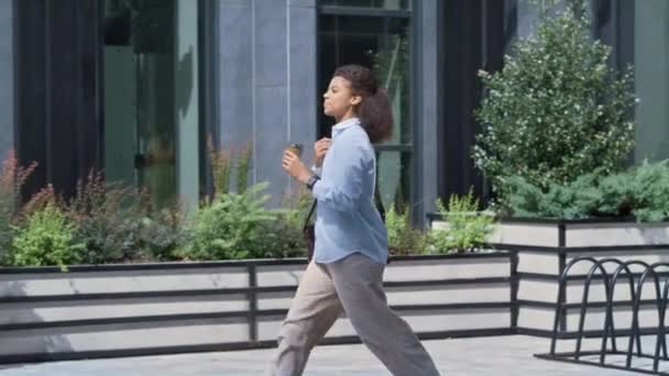 Wanita tersenyum memegang cangkir kopi berjalan-jalan di sekitar kota. Konsep orang perusahaan. — Stok Video