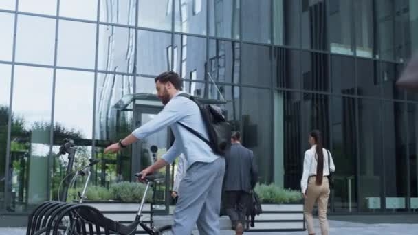 Ofisten bisikletle ayrılan bir yönetici. Modern şehir hareketlilik aracı. — Stok video