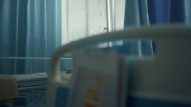 Gülümseyen anne kızını ziyaret ediyor. Hastane odasında tablet bilgisayarda oynuyorlar.