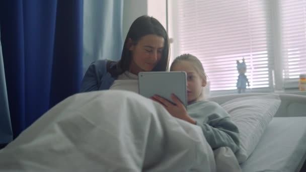 Uśmiechnięta dziewczyna bawi się z matką na oddziale. Wspierający rodzic odwiedzający chore dziecko. — Wideo stockowe