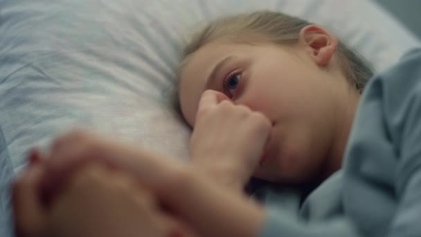 Słodka dziewczyna leżąca szpitalny portret łóżka. Matka delikatnie trzyma dziecko za rękę zbliżenie. — Wideo stockowe