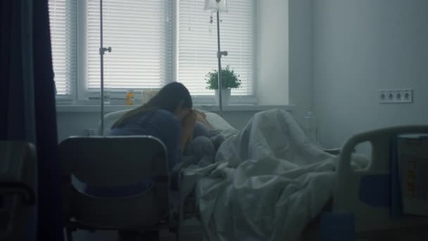 Мати турбується про хвору дитину після терапії в клініці. Серйозно хвора дитина лежить в ліжку . — стокове відео