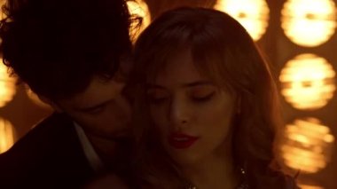Kulüpte dans eden seksi erkek kıza sarılıyor. Genç aşıklar birlikte hareket ediyor.