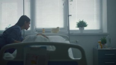 Anne hasta kızı öpüyor, yatakta yatıyor. Destekleyici ebeveyn hasta koğuşu