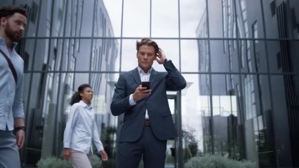 Un hombre de negocios seguro recibe buenas noticias sobre el retrato de teléfonos inteligentes. Concepto de victoria — Vídeos de Stock